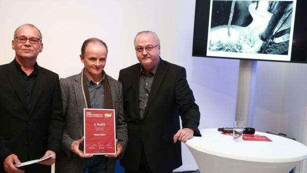 Drei Männer posieren mit einer Urkunde für den 2. Platz eines Fotowettbewerbs.