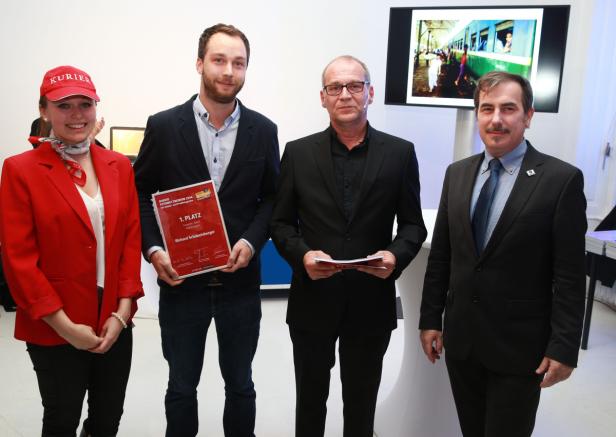 Vier Personen posieren bei einer Preisverleihung für ein Foto.