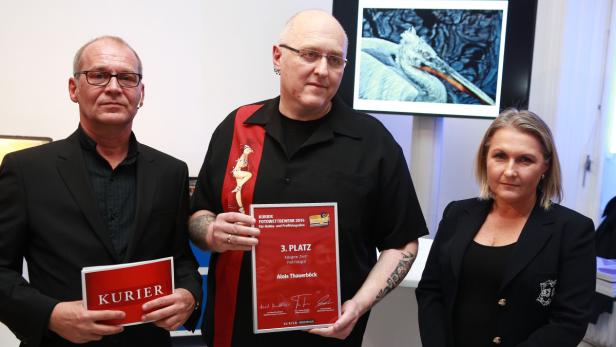 Drei Personen posieren mit einer Urkunde für den „Kurier Fotowettbewerb 2014“ und einem „Kurier“-Magazin.