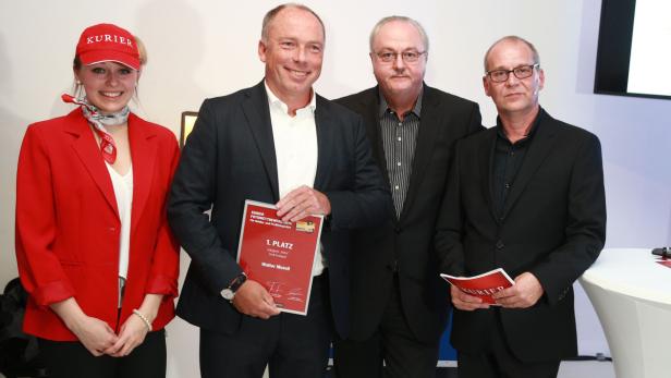 Eine Gruppe von Personen posiert mit einer Urkunde des Kurier Fotowettbewerbs 2014.