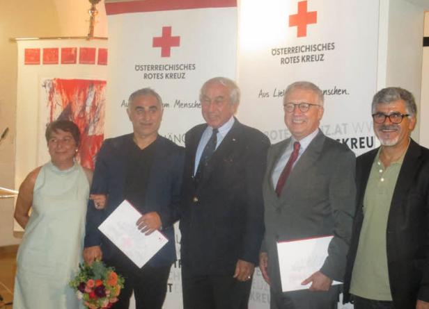 Eine Gruppe von Personen posiert vor einem Banner des Österreichischen Roten Kreuzes.
