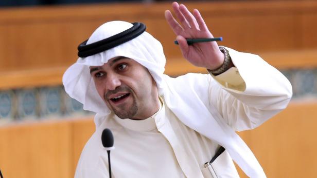 Ein Mann in traditioneller arabischer Kleidung gestikuliert mit einem Stift in der Hand.