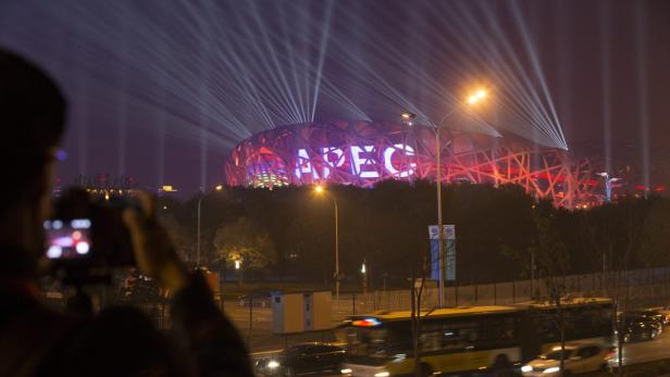 Das Nationalstadion Peking, auch bekannt als „Vogelnest“, ist nachts mit APEC beleuchtet.