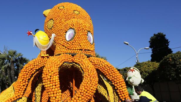 Eine riesige Oktopus-Skulptur, gefertigt aus Orangen und Zitronen, steht im Freien.