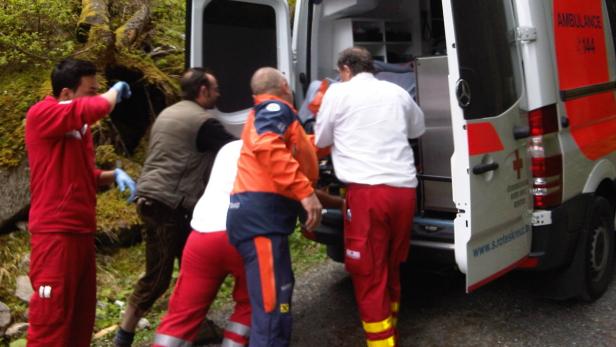 Rettungskräfte laden eine Person in einen Krankenwagen des Österreichischen Roten Kreuzes.