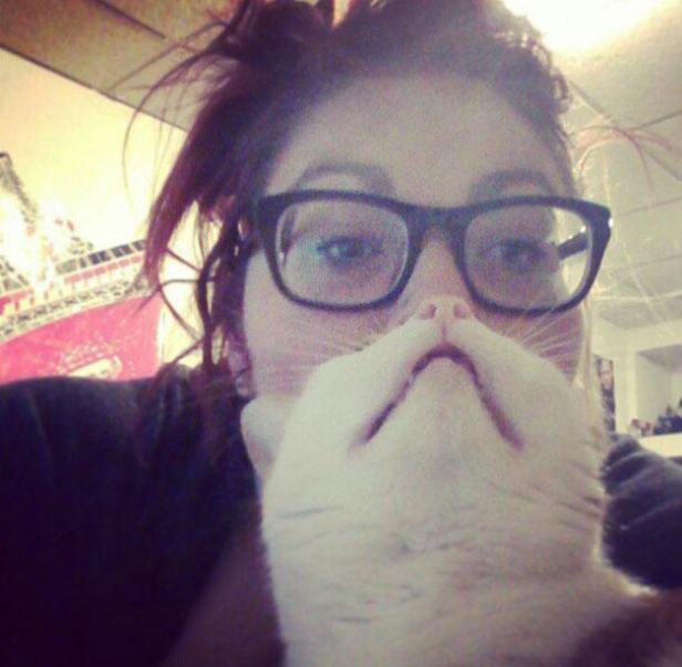 Eine Frau macht ein Selfie mit ihrer Katze, die ihr Gesicht verdeckt.