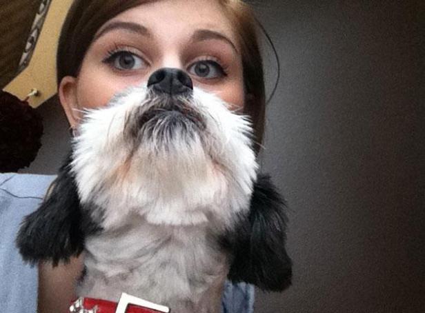 Eine Frau hält einen Hund so, dass es aussieht, als hätte sie einen Bart.