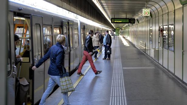 Menschen steigen in einer U-Bahnstation in einen Zug ein und aus.