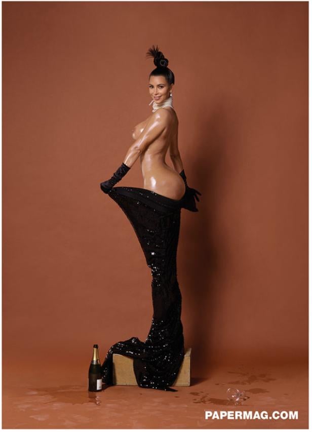 Kim Kardashian posiert mit glitzerndem Kleid und hochgesteckter Frisur für ein Foto.