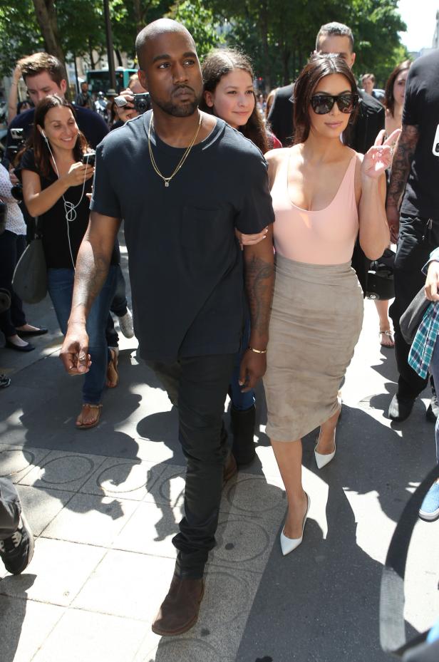 Kanye West und Kim Kardashian werden von Paparazzi umringt.