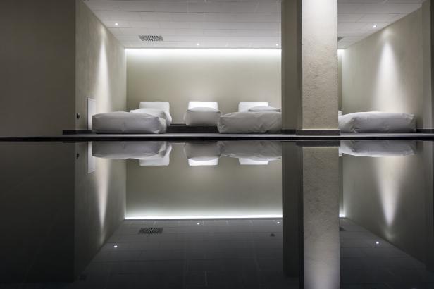 Ein Ruheraum mit Liegen und Spiegelung im Wasser.