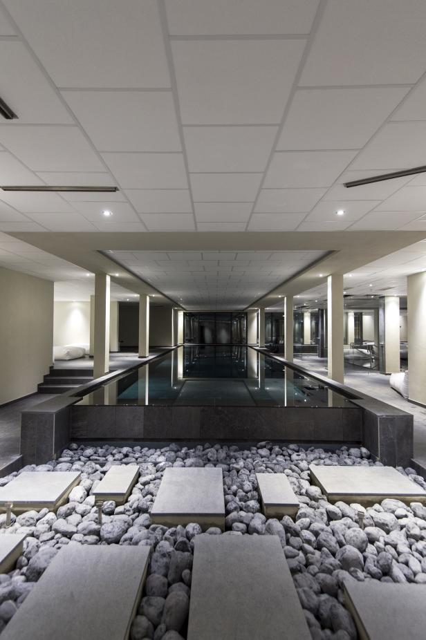 Ein Innenpool mit Steinen und Steinplatten im Vordergrund.