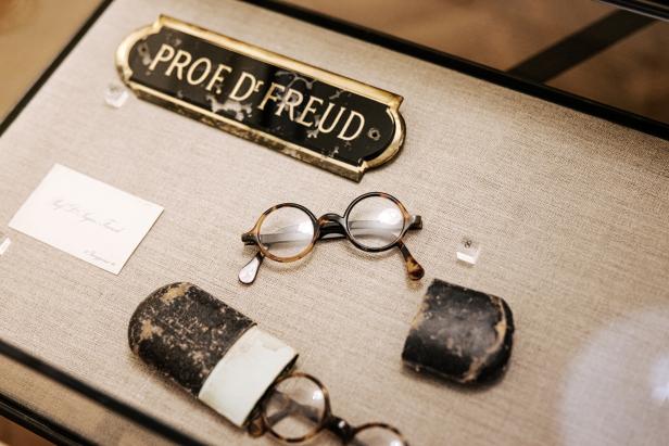 Die Brille und das Namensschild von Prof. Dʳ Freud in einer Vitrine.