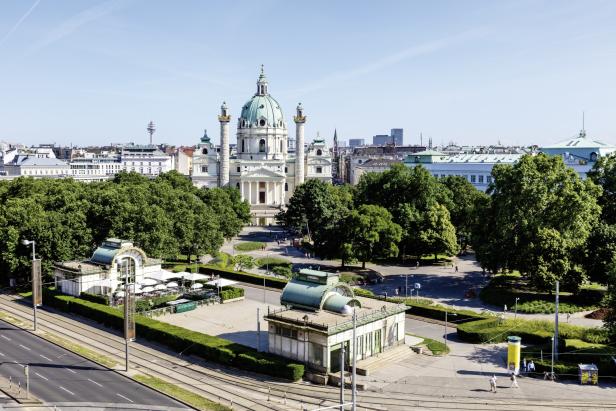Die Karlskirche in Wien, umgeben von Bäumen und historischen Gebäuden.
