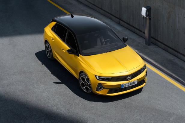 Ein gelber Opel Astra steht an einer Ladestation.