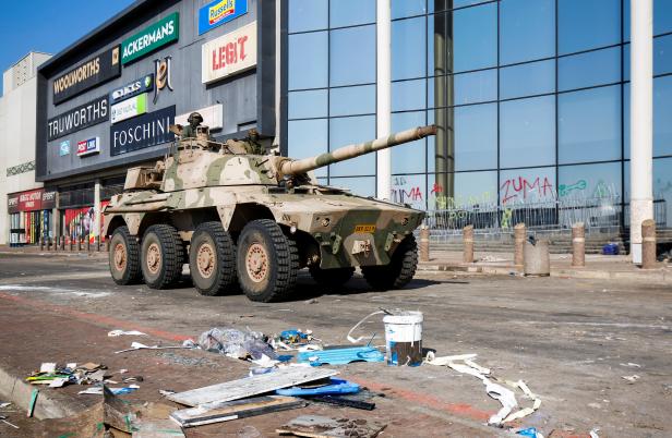 A military tank patrols near a shopping centre which was damaged after several days of looting following the imprisonment of former South Africa President Jacob Zuma in Durban