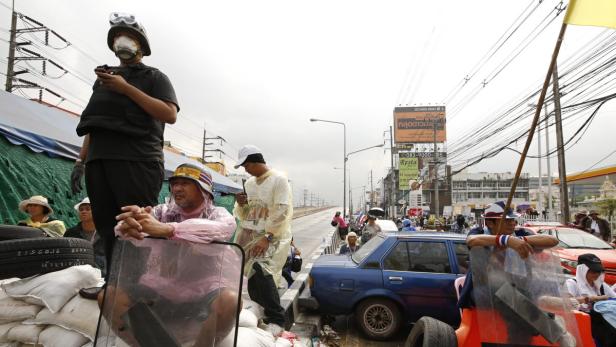 Eine Gruppe von Demonstranten steht auf einer Straße in Thailand.