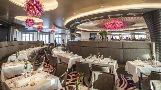 Ein elegantes Restaurant mit gedeckten Tischen und dekorativen Glasleuchtern.