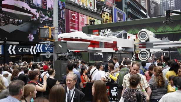 Eine Menschenmenge versammelt sich um ein großes Lego-Modell eines X-Wing-Raumschiffs in New York City.