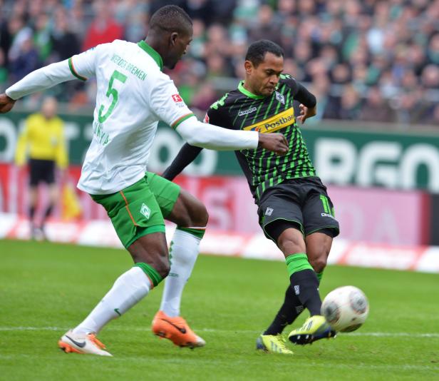 Zwei Fußballspieler kämpfen um den Ball auf dem Spielfeld.