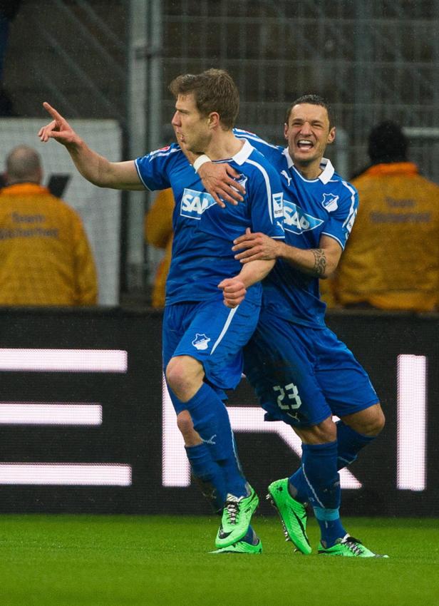 Zwei Fußballspieler in blauen Trikots feiern ein Tor.