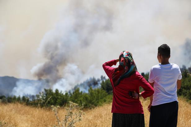 Locals watch a wildfire near the town of Manavgat