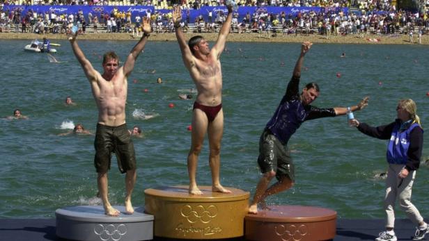 Triathleten feiern ihren Sieg auf dem Podium bei den Olympischen Spielen in Sydney 2000.