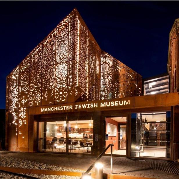 Das Manchester Jewish Museum bei Nacht mit seiner markanten Fassade.