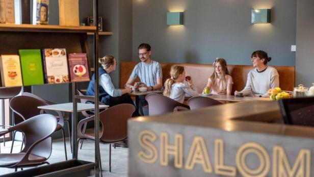 Eine Familie sitzt im Manchester Jewish Museum Café beisammen.