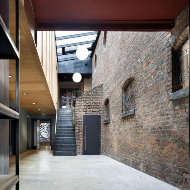 Innenansicht des Manchester Jewish Museum mit Treppe und Backsteinmauer.