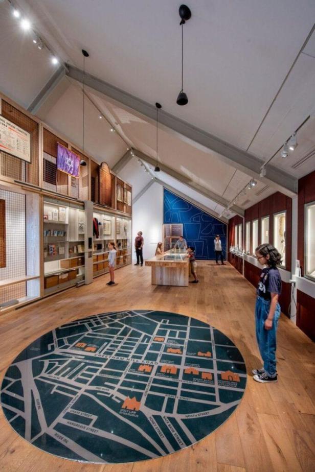 Besucher erkunden das Jüdische Museum in Manchester mit einer Karte auf dem Boden.