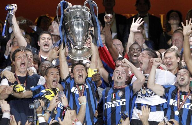 Jubelnde Fußballspieler von Inter Mailand mit der Trophäe der UEFA Champions League.