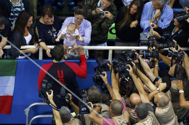 Michael Phelps wird von seiner Familie und einer Menge Fotografen umgeben.