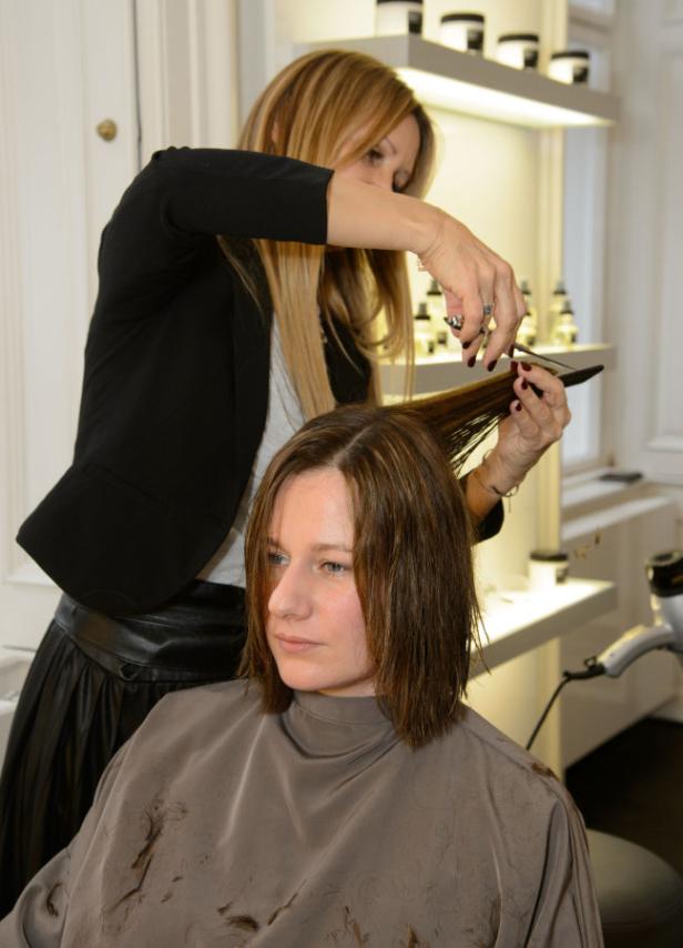 Eine Frau bekommt im Friseursalon die Haare geschnitten.