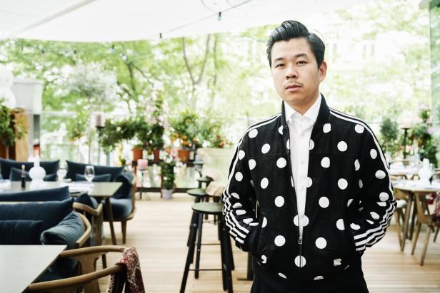 Ein Mann mit gepunkteter Jacke steht in einem Restaurant.