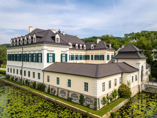 Schloss Laudon, umgeben von einem Wassergraben mit Seerosen, in Wien, Österreich.