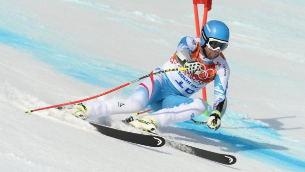 Ein Skirennläufer fährt in voller Montur einen Hang hinunter.