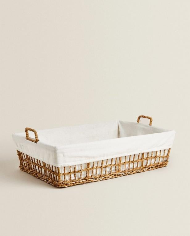 Ein rechteckiger Wäschekorb aus Korbweide mit einem weißen Stoffeinsatz.