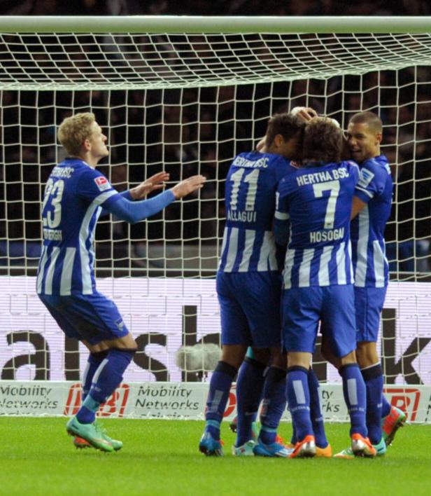 Hertha BSC-Spieler feiern ein Tor vor dem Netz.