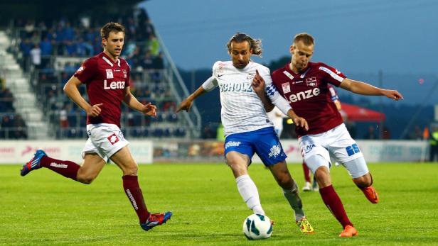 Stefan Lexa nahm Abschied Drei Fußballspieler kämpfen um den Ball auf dem Spielfeld.