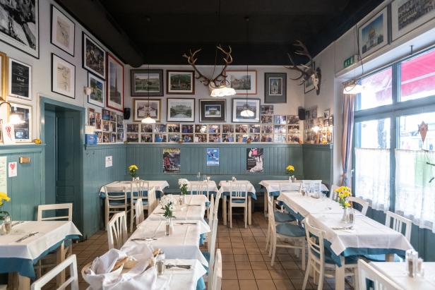 Ein einladendes Restaurant mit gedeckten Tischen und dekorativen Bildern an den Wänden.