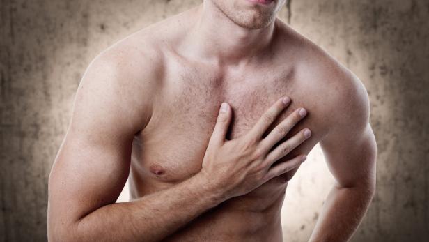 Ein Mann hält seine Hand auf seine Brust.