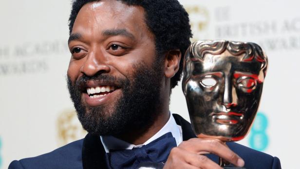 Chiwetel Ejiofor hält eine BAFTA-Trophäe.