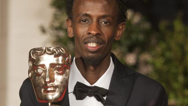 Barkhad Abdi hält eine goldene BAFTA-Maske.