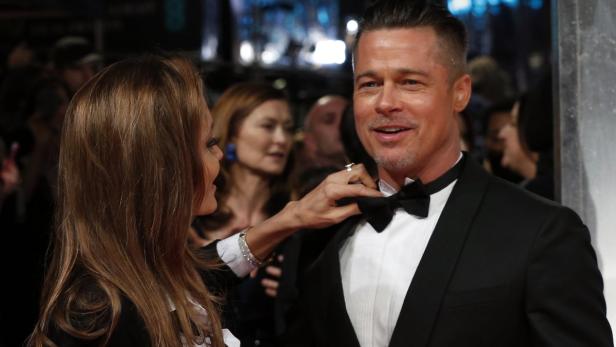 Angelina Jolie richtet Brad Pitts Fliege auf dem roten Teppich.