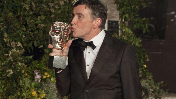 Steve Coogan küsst seine BAFTA-Trophäe.