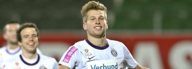 Ein lächelnder Fußballspieler im Trikot des FK Austria Wien.