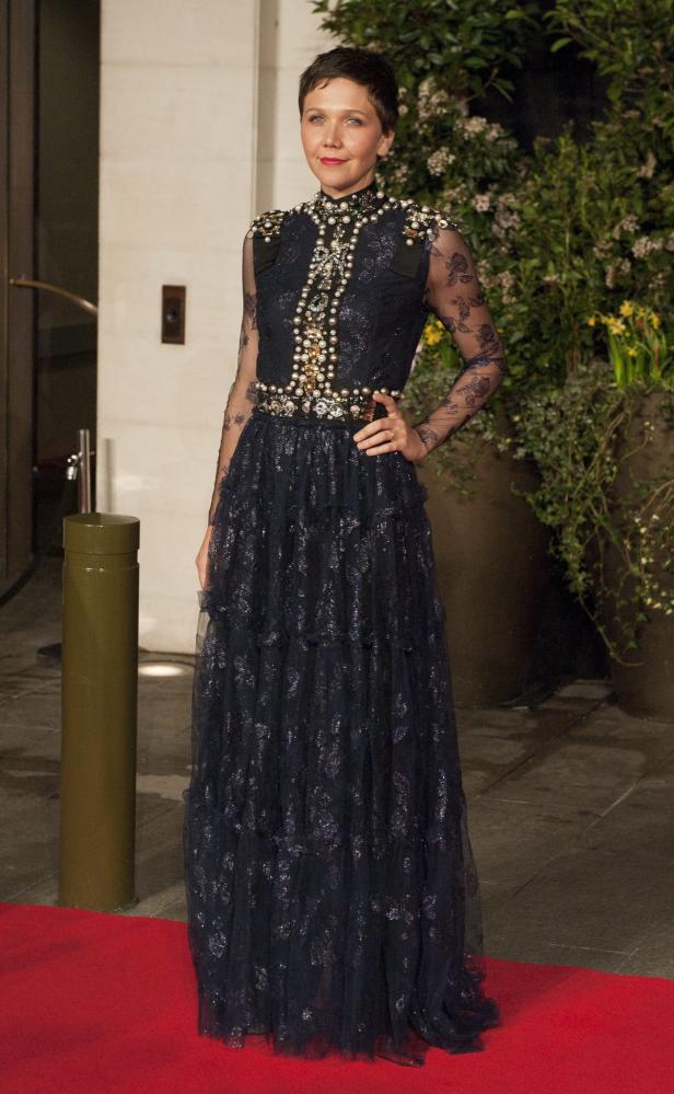 Maggie Gyllenhaal in einem langen, dunklen Kleid mit Perlen und Spitze.