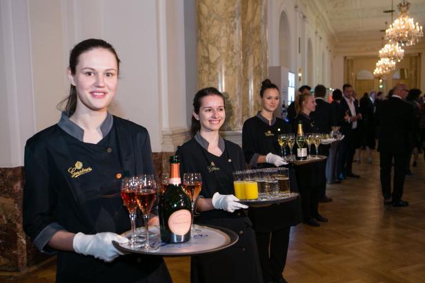 Drei Kellnerinnen von Gerstner servieren Getränke auf einem Empfang.