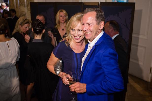 Ein lächelndes Paar mit Champagnergläsern auf einer Veranstaltung.